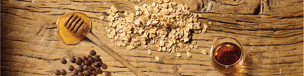 Honey, cocoa chips, oats and maple syrup ingredients on wooden table