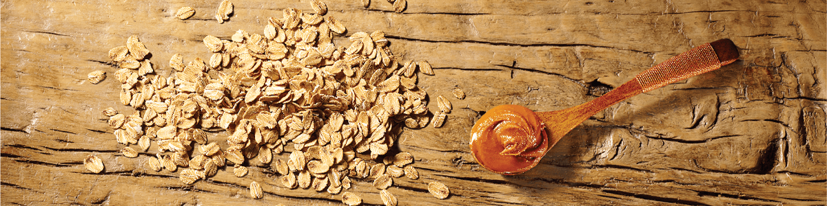 Oats and peanut butter ingredients on wooden table