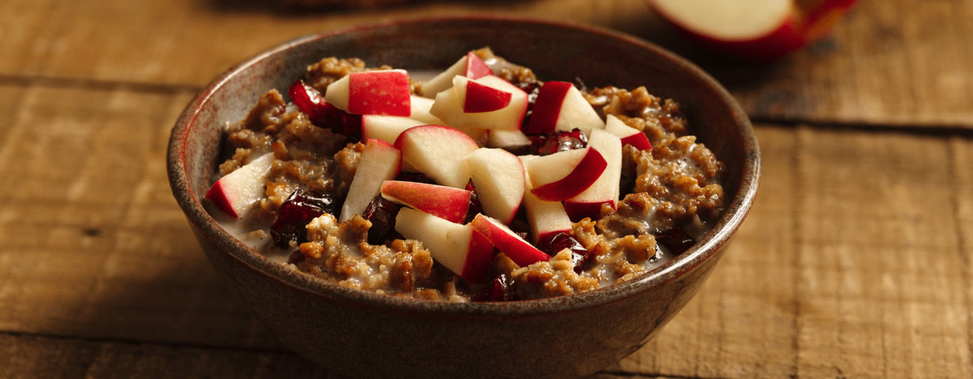 Bowl of granola cereal with chopped apples on top