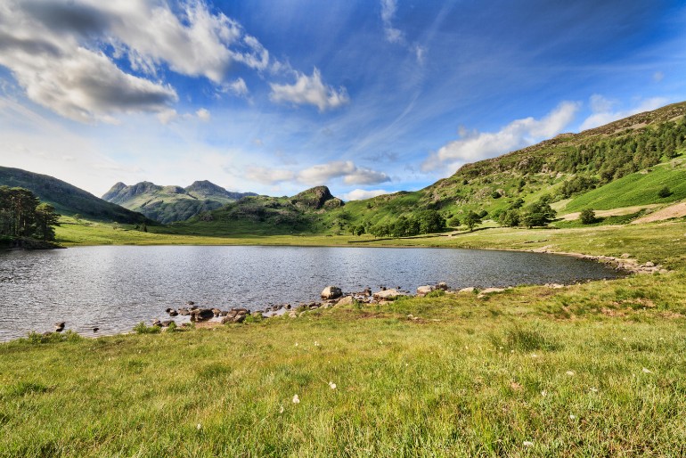 Blea Tarn - a circular shaped lake surrounded by green pastures and hills.